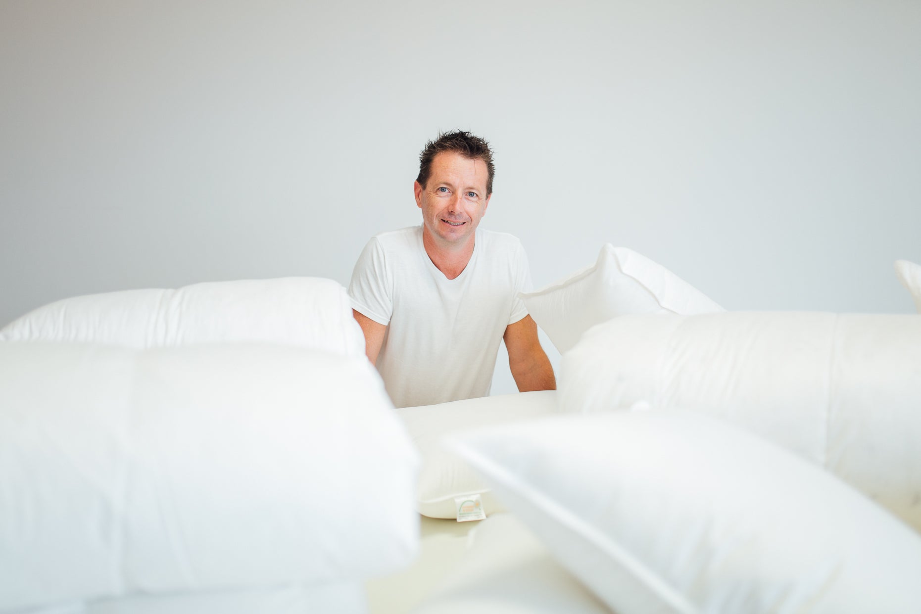 Shane, the owner of Supreme Quilts is surrounded by quilts, duvets, blankets, comforters, mattress toppers and pillows that were ethically sourced from Poland and hand-made in Australia